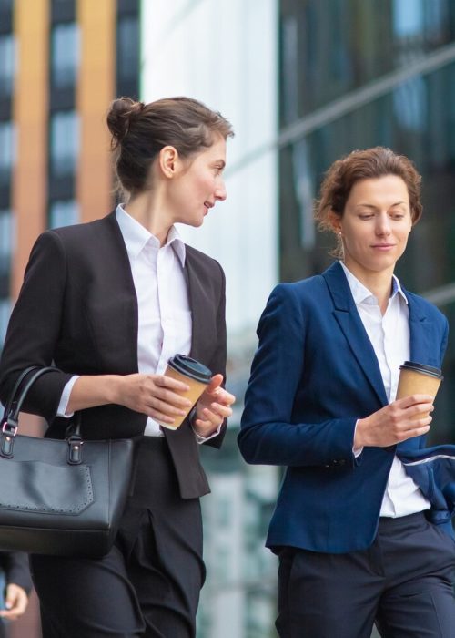 young-female-managers-with-takeaway-coffee-mugs-wearing-office-suits-walking-together-city-talking-discussing-project-chatting-medium-shot-work-break-concept_74855-7863